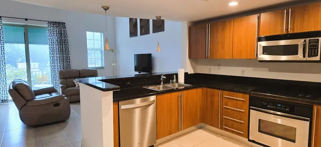 a kitchen with stainless steel appliances granite countertop a stove a sink and a microwave