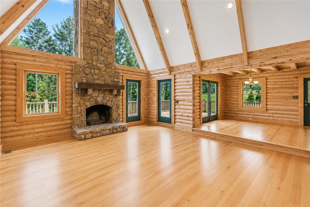 414 Devon Way Anderson, SC 29621 - Photo 6 of 50 A grand, naturally illuminated living area showcases soaring ceilings, natural wood walls, and a prominent stone fireplace.
