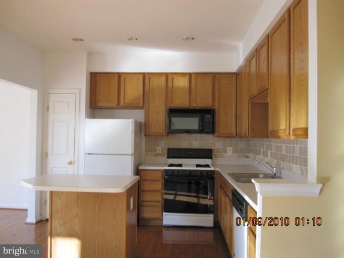 10168 Elgin Way Bristow, VA 20136 - Photo 2 of 6 a kitchen with a stove a sink and a refrigerator