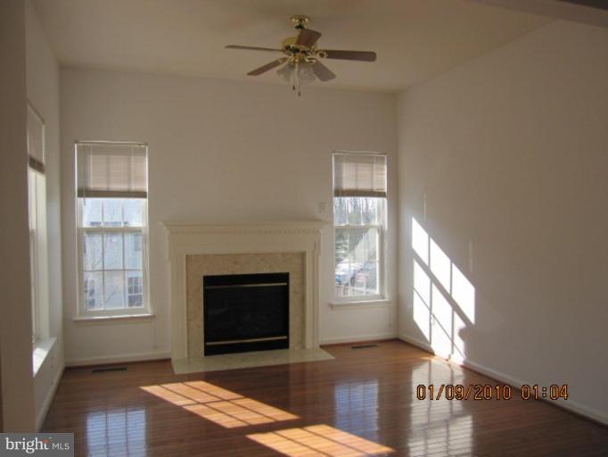 10168 Elgin Way Bristow, VA 20136 - Photo 3 of 6 an empty room with windows and fireplace