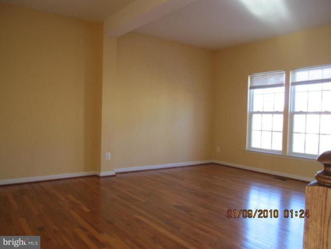 10168 Elgin Way Bristow, VA 20136 - Photo 5 of 6 a view of an empty room with wooden floor and a window