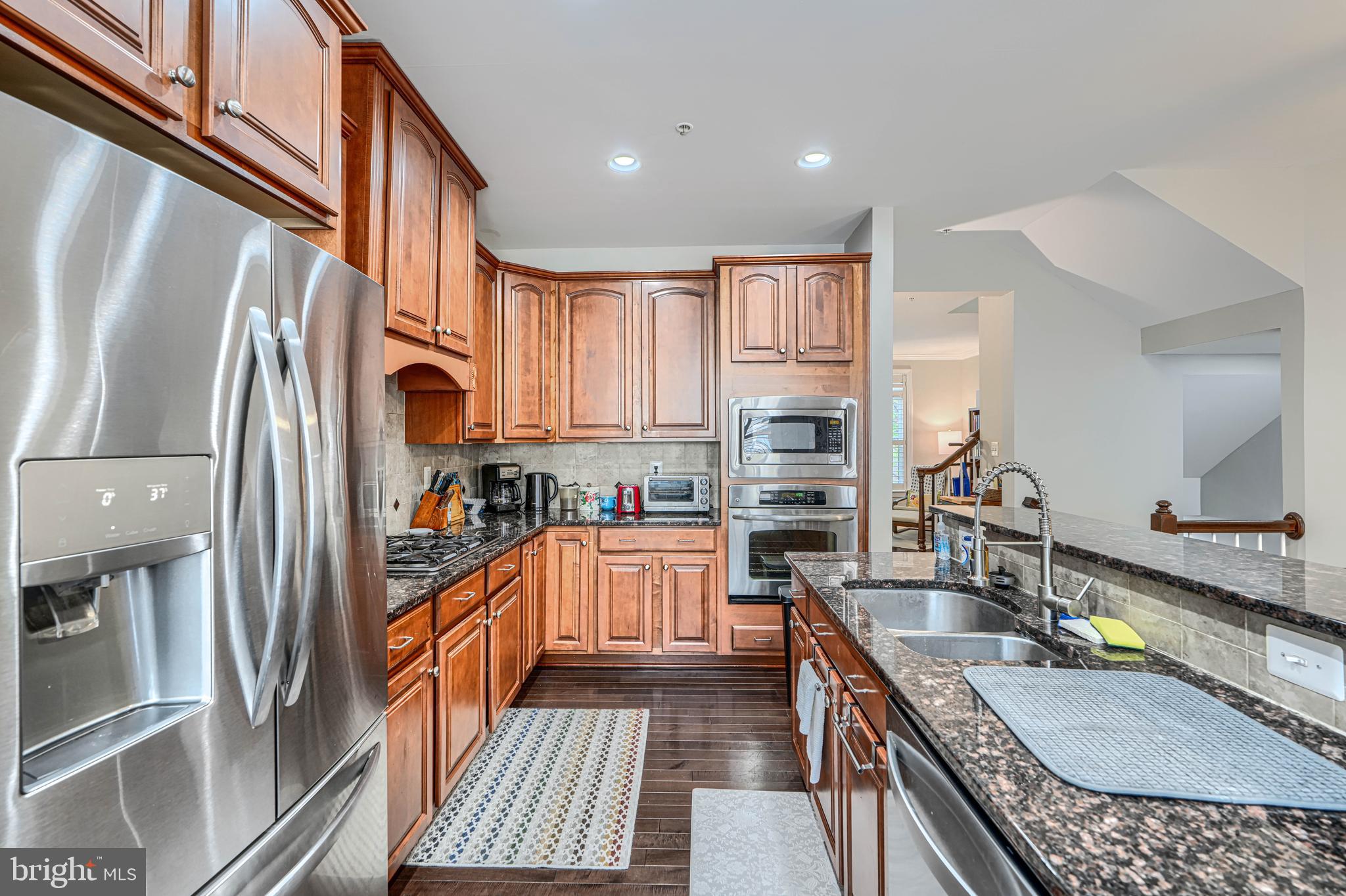 432 Grand Street Gaithersburg, MD 20878 - Photo 17 of 48 a kitchen with stainless steel appliances granite countertop a refrigerator a stove and a sink with wooden floor