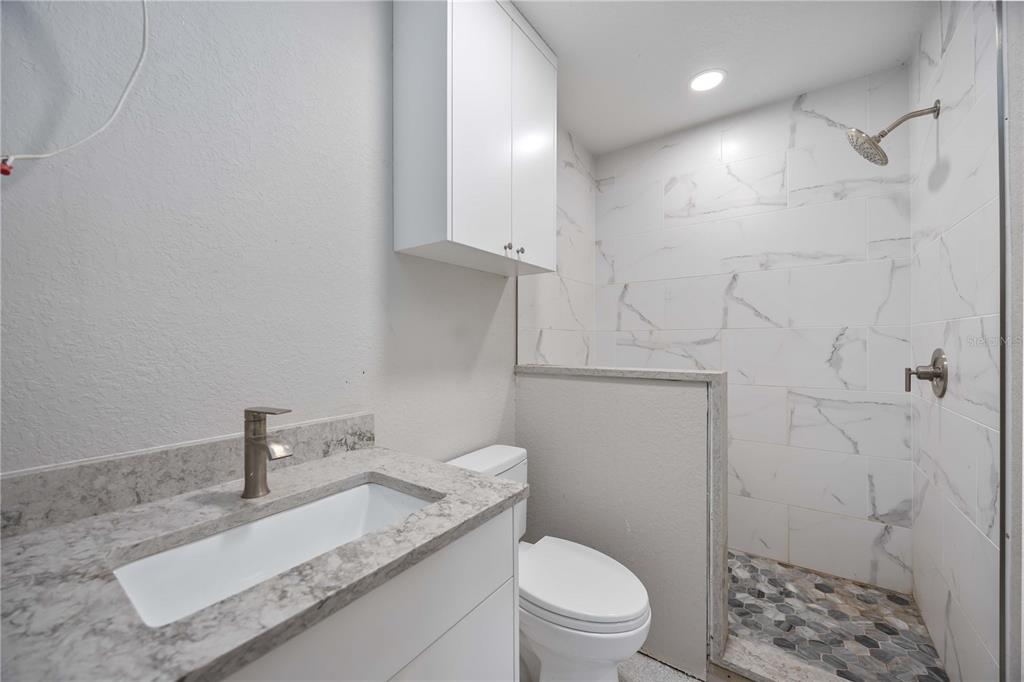 3254 Elliott Street Venice, FL 34292 - Photo 12 of 23 a bathroom with a granite countertop toilet a sink a shower and vanity