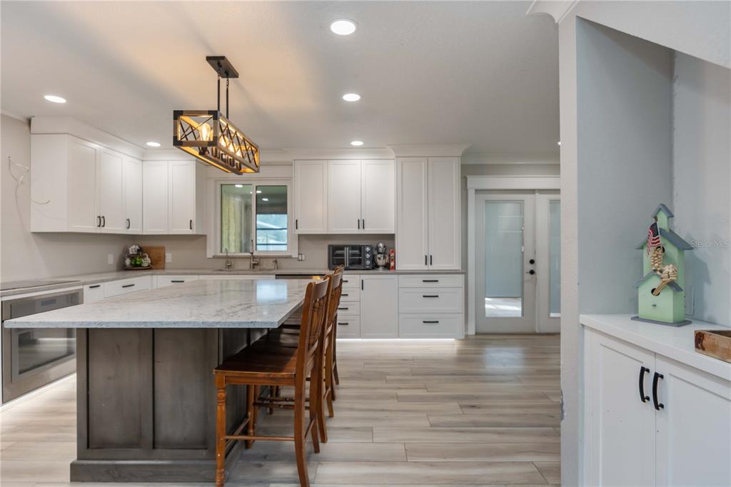 3254 Elliott Street Venice, FL 34292 - Photo 2 of 23 a kitchen with kitchen island a dining table chairs sink and cabinets
