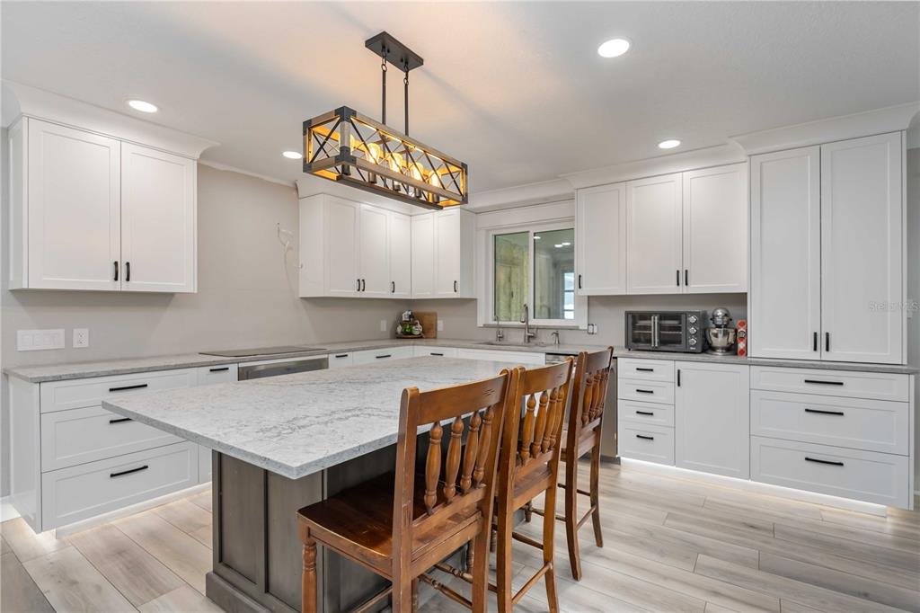 3254 Elliott Street Venice, FL 34292 - Photo 4 of 23 a kitchen with a center island white cabinets and stainless steel appliances