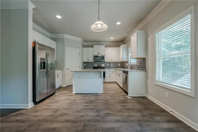 a kitchen with kitchen island a sink stainless steel appliances and cabinets