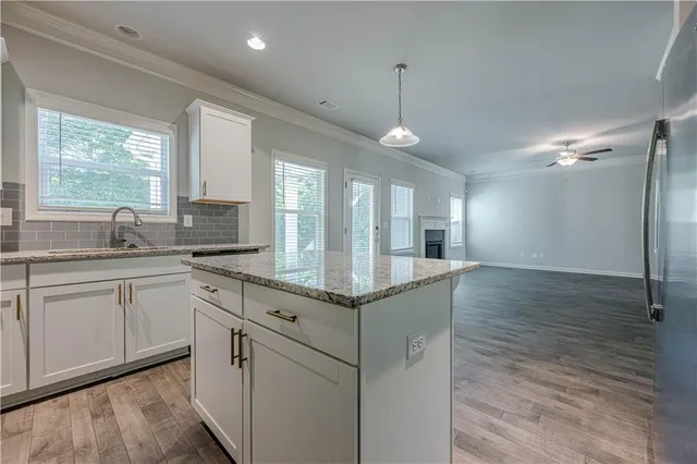 a kitchen with granite countertop a sink and cabinets