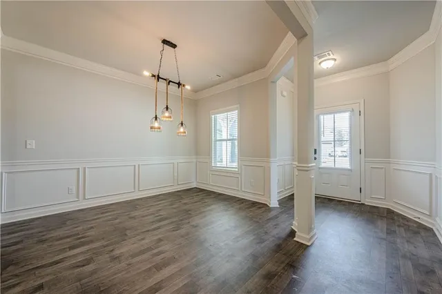 a view of empty room with wooden floor and window