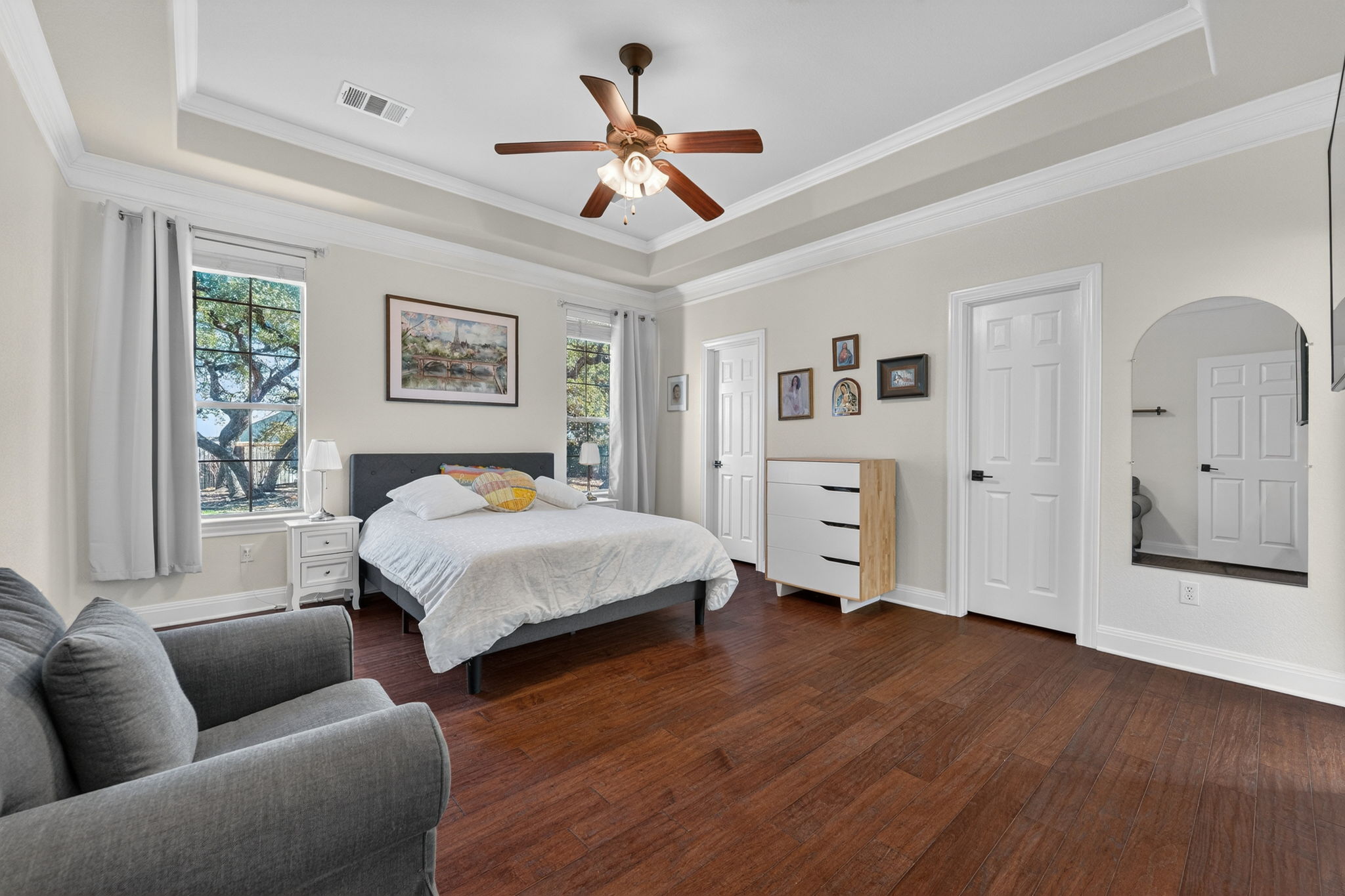 117 Lakota Pass Austin, TX 78738 - Photo 11 of 18 Bedroom with dark wood-type flooring, a raised ceiling, ornamental molding, and ceiling fan