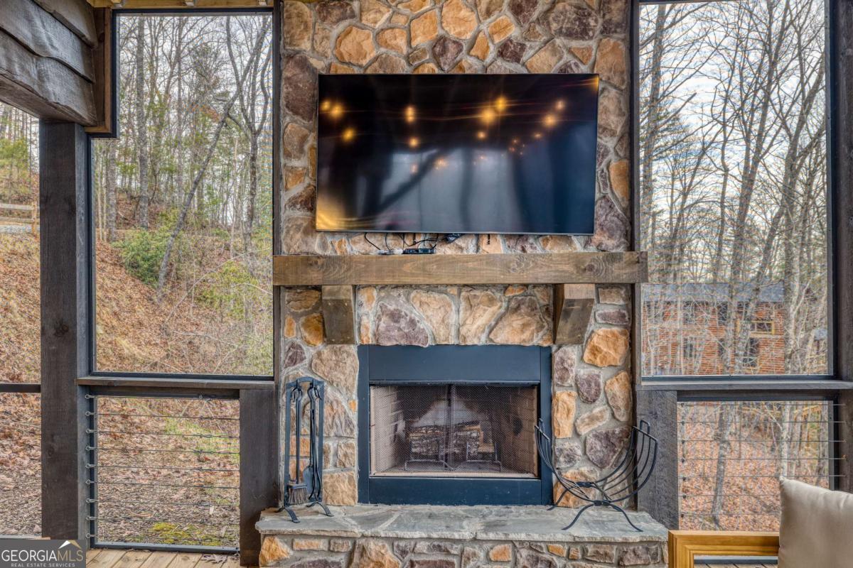 49 Chestnut Overlook Blue Ridge, Unit 11 Blue Ridge, GA 30513 - Photo 34 of 62 a living room with a fireplace and a flat screen tv