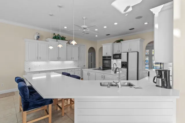 a kitchen with stainless steel appliances granite countertop a refrigerator and white cabinets