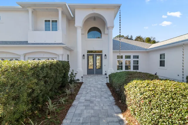 a front view of a house with a yard and potted plants