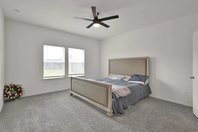 a bed sitting in a bedroom next to a window