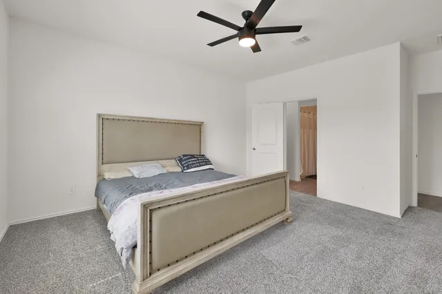 a room with a bed and a ceiling fan
