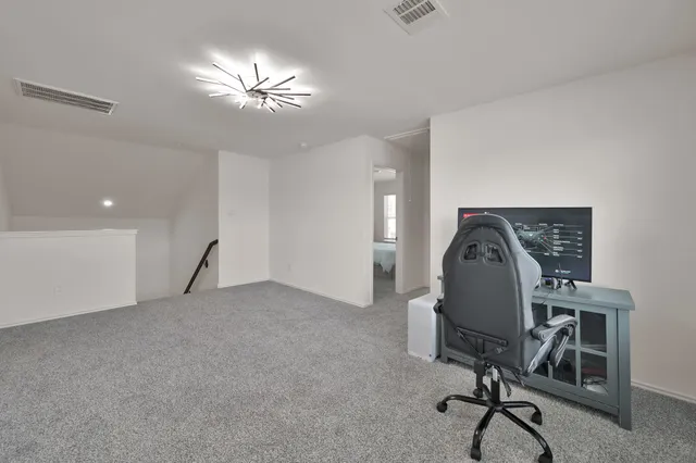 a view of a workspace with furniture and a chandelier