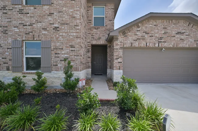 a stone house with a yard and plants