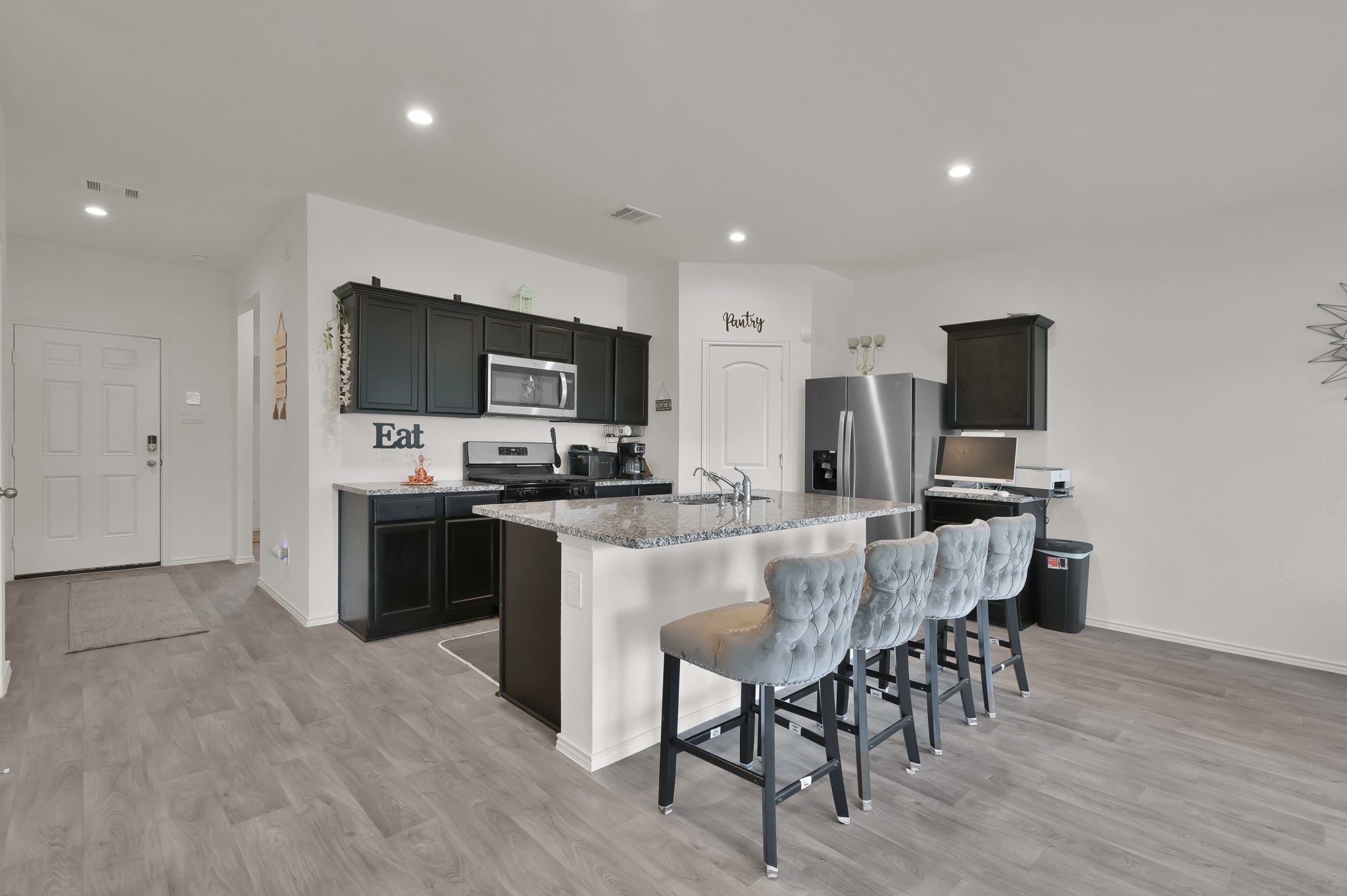 14212 Dream Road New Caney, TX 77357 - Photo 7 of 37 a kitchen with stainless steel appliances a microwave a stove a sink a refrigerator and chairs