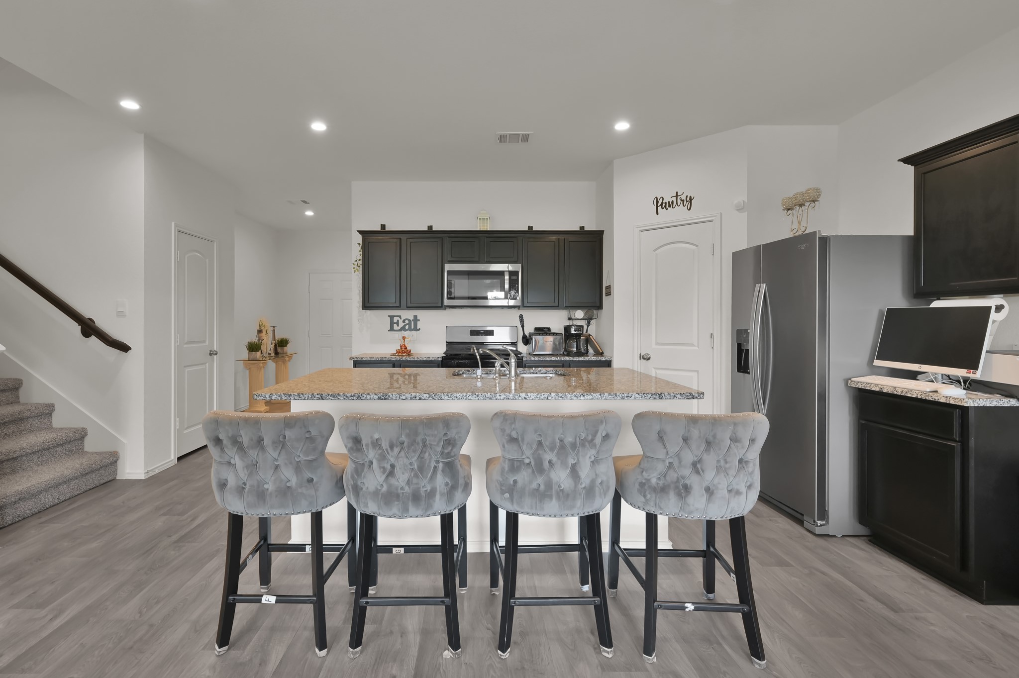 14212 Dream Road New Caney, TX 77357 - Photo 8 of 37 a kitchen with stainless steel appliances granite countertop a dining table chairs refrigerator and microwave