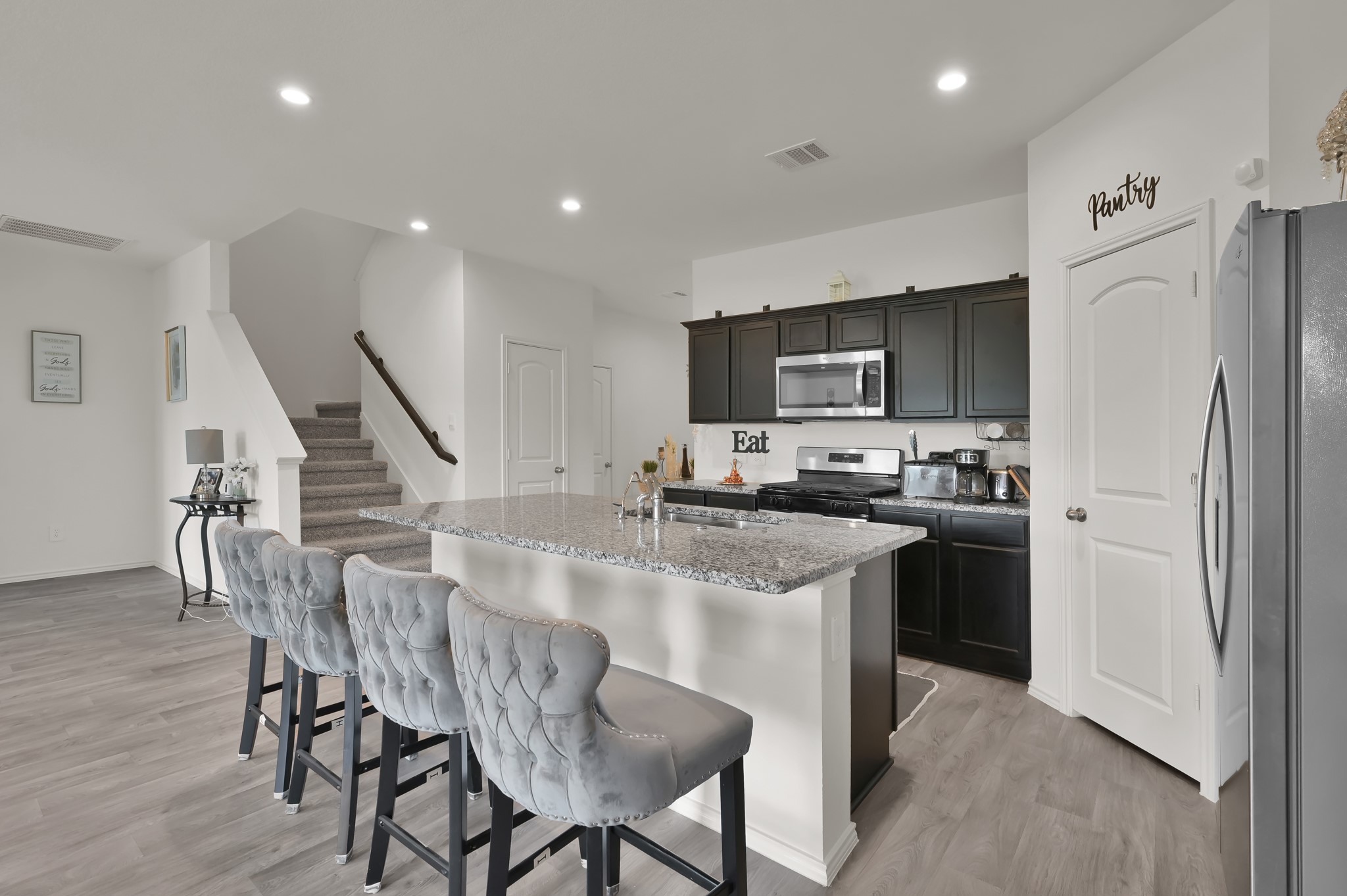 14212 Dream Road New Caney, TX 77357 - Photo 9 of 37 a kitchen with stainless steel appliances granite countertop a refrigerator a stove a microwave oven a dining table and chairs