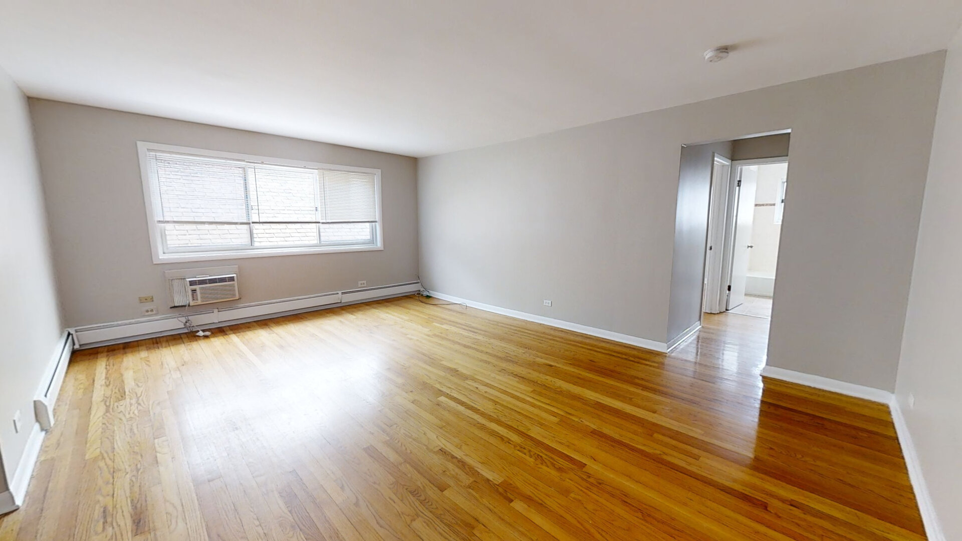 828 Seward Street, Unit 2E Evanston, IL 60202 - Photo 2 of 12 an empty room with wooden floor and windows