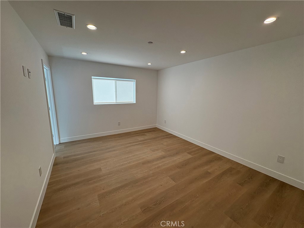 14165 Calvert Street Van Nuys, CA 91401 - Photo 14 of 21 an empty room with wooden floor and windows