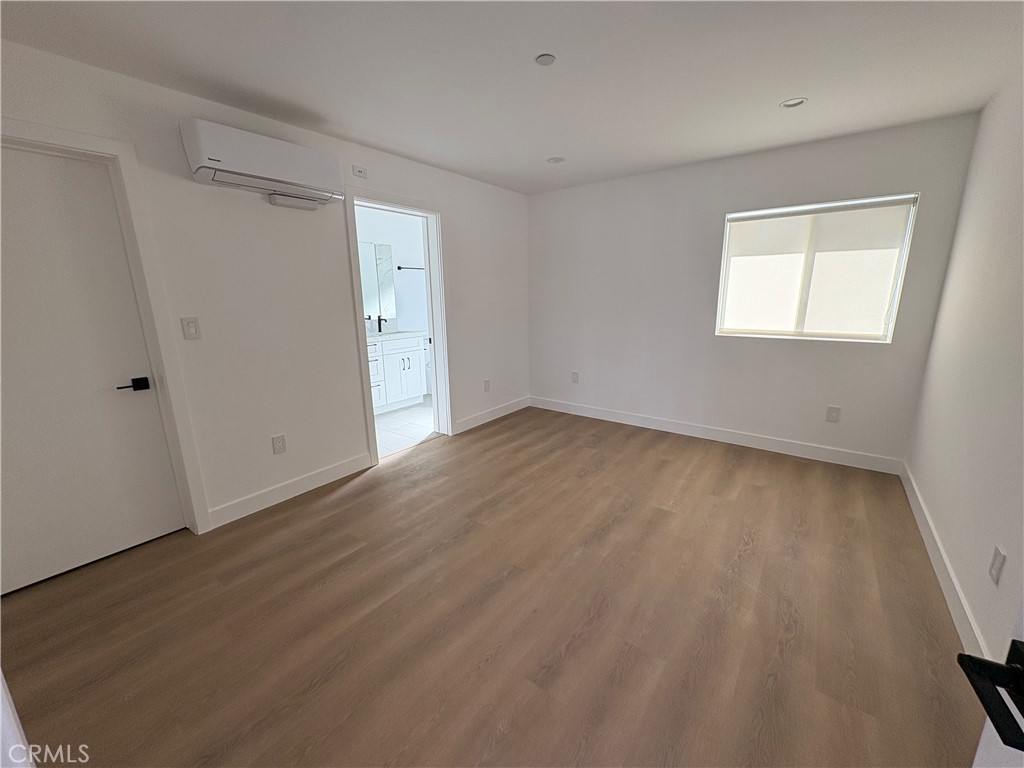 14165 Calvert Street Van Nuys, CA 91401 - Photo 15 of 21 a view of an empty room with wooden floor and a window