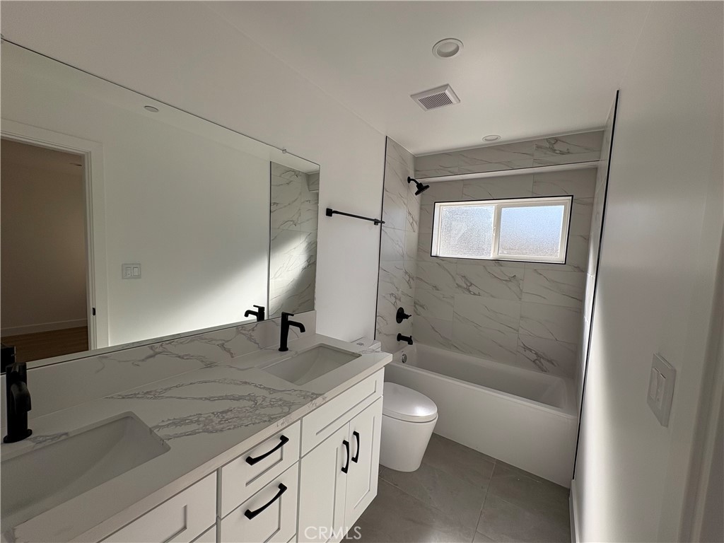 14165 Calvert Street Van Nuys, CA 91401 - Photo 4 of 21 a bathroom with a granite countertop sink a toilet and shower