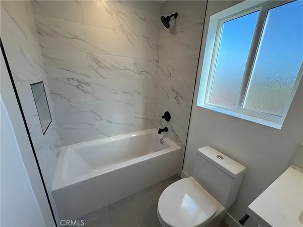 a white toilet sitting next to a bath tub