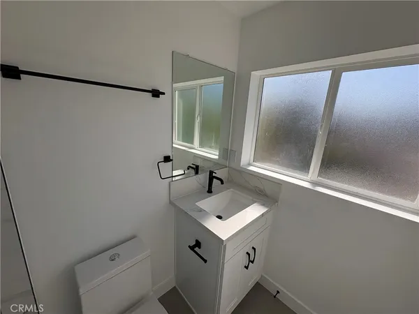 a bathroom with a sink mirror vanity and toilet