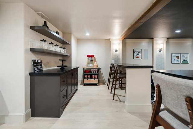 1141 South Oak Leaf Lane Springville, UT 84663 - Photo 103 of 147 Entertainment space featuring light wood-finish flooring, dark built-in cabinetry with a dark countertop, and two floating shelves