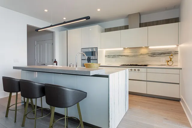 a kitchen with cabinets and chairs