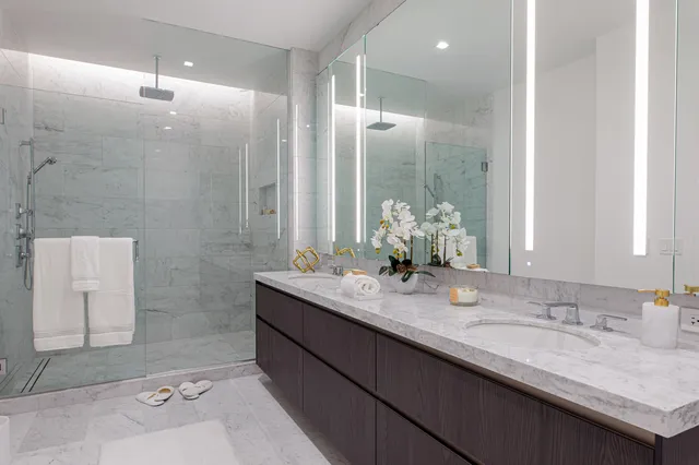 a bathroom with a granite countertop sink a mirror and a shower