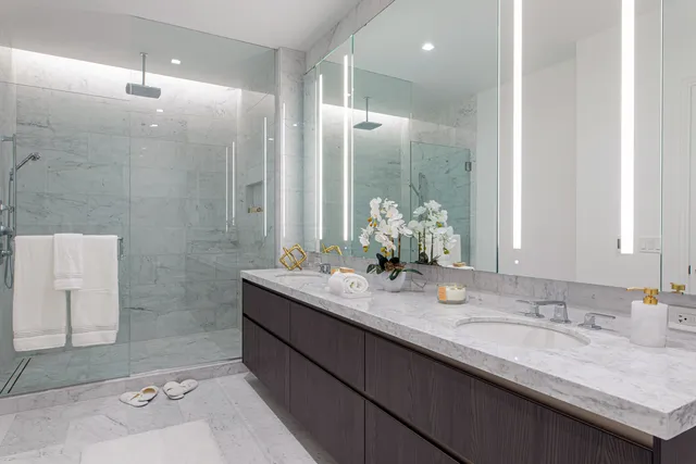 a bathroom with a granite countertop sink a mirror and a shower