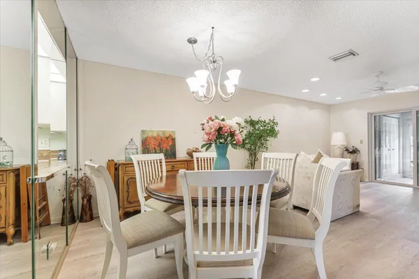 a view of a dining room with furniture and a chandelier