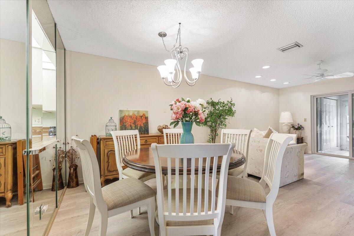 5178 Privet Place, Unit D Delray Beach, FL 33484 - Photo 16 of 41 a view of a dining room with furniture and a chandelier