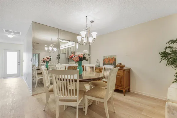 a view of a dining room with furniture and chandelier