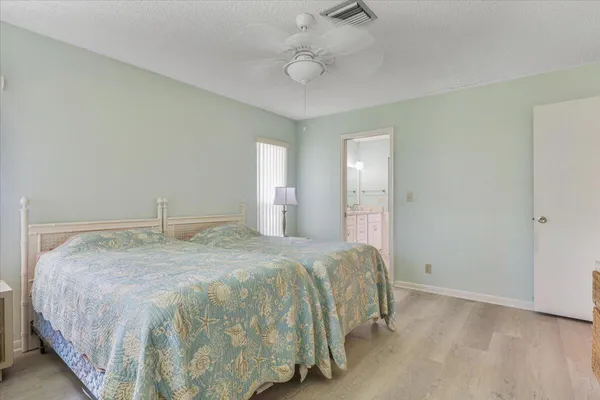 a bedroom with a bed and closet with wooden floor