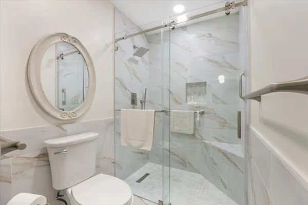 a white toilet sitting next to a bathroom sink
