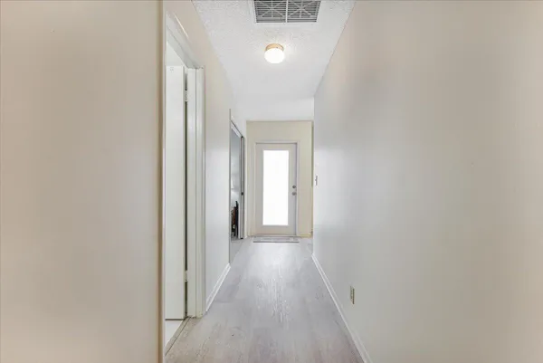 a view of a hallway with wooden floor