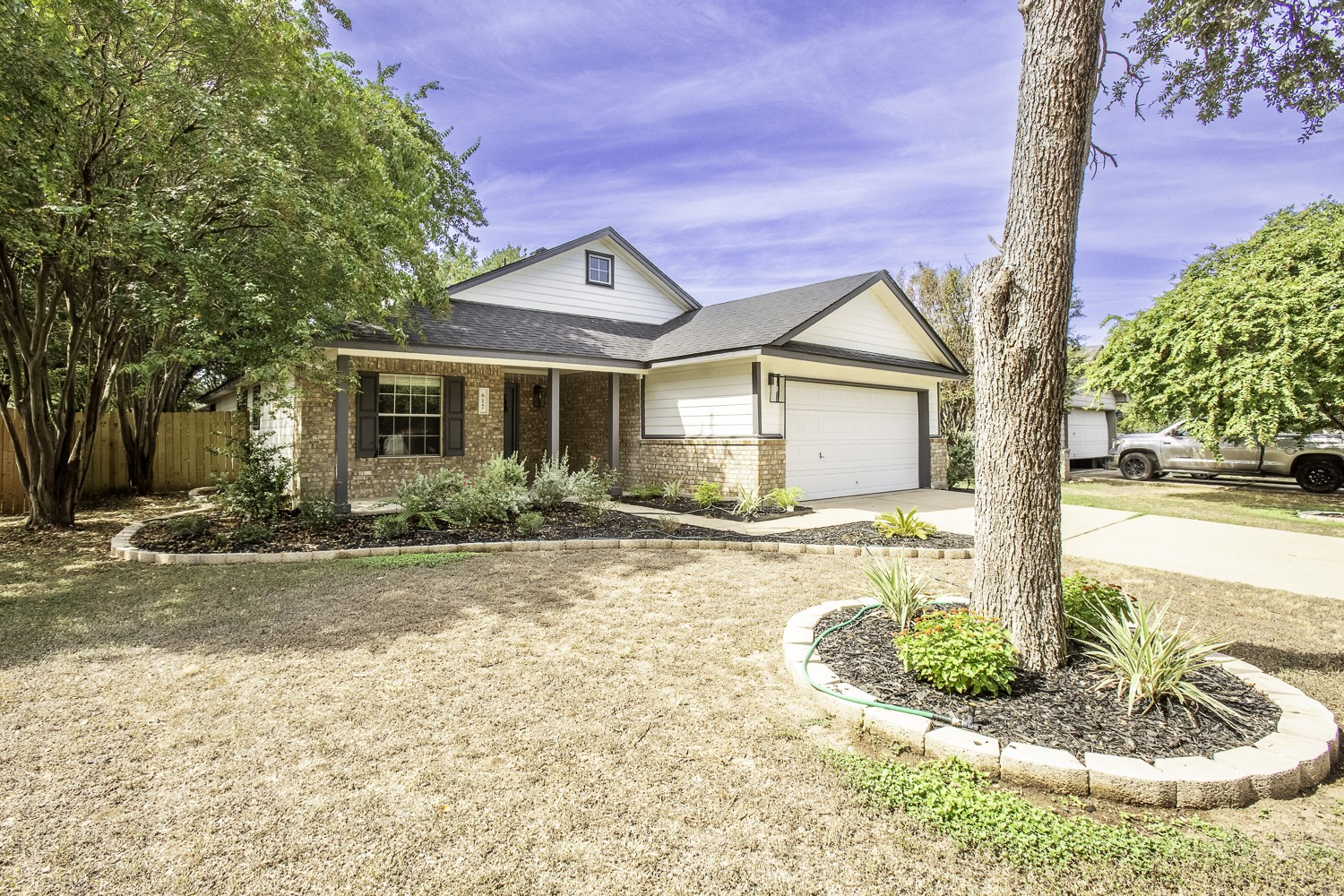 617 Barbara Way Bastrop, TX 78602 - Photo 2 of 39 Traditional-style home with driveway, brick siding, a porch, roof with shingles, and an attached garage