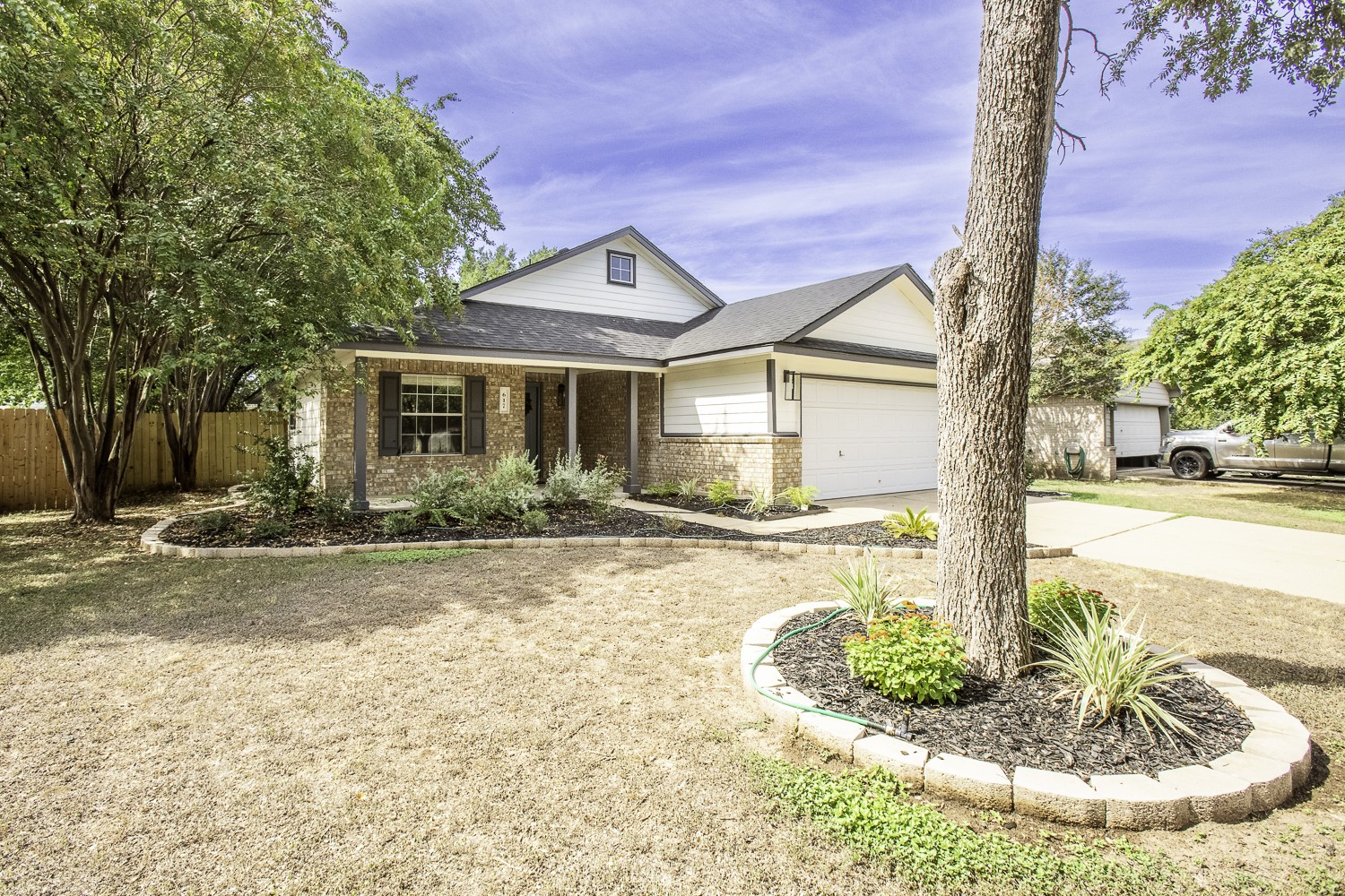 617 Barbara Way Bastrop, TX 78602 - Photo 5 of 39 View of front of house with brick siding, driveway, a porch, a shingled roof, and an attached garage