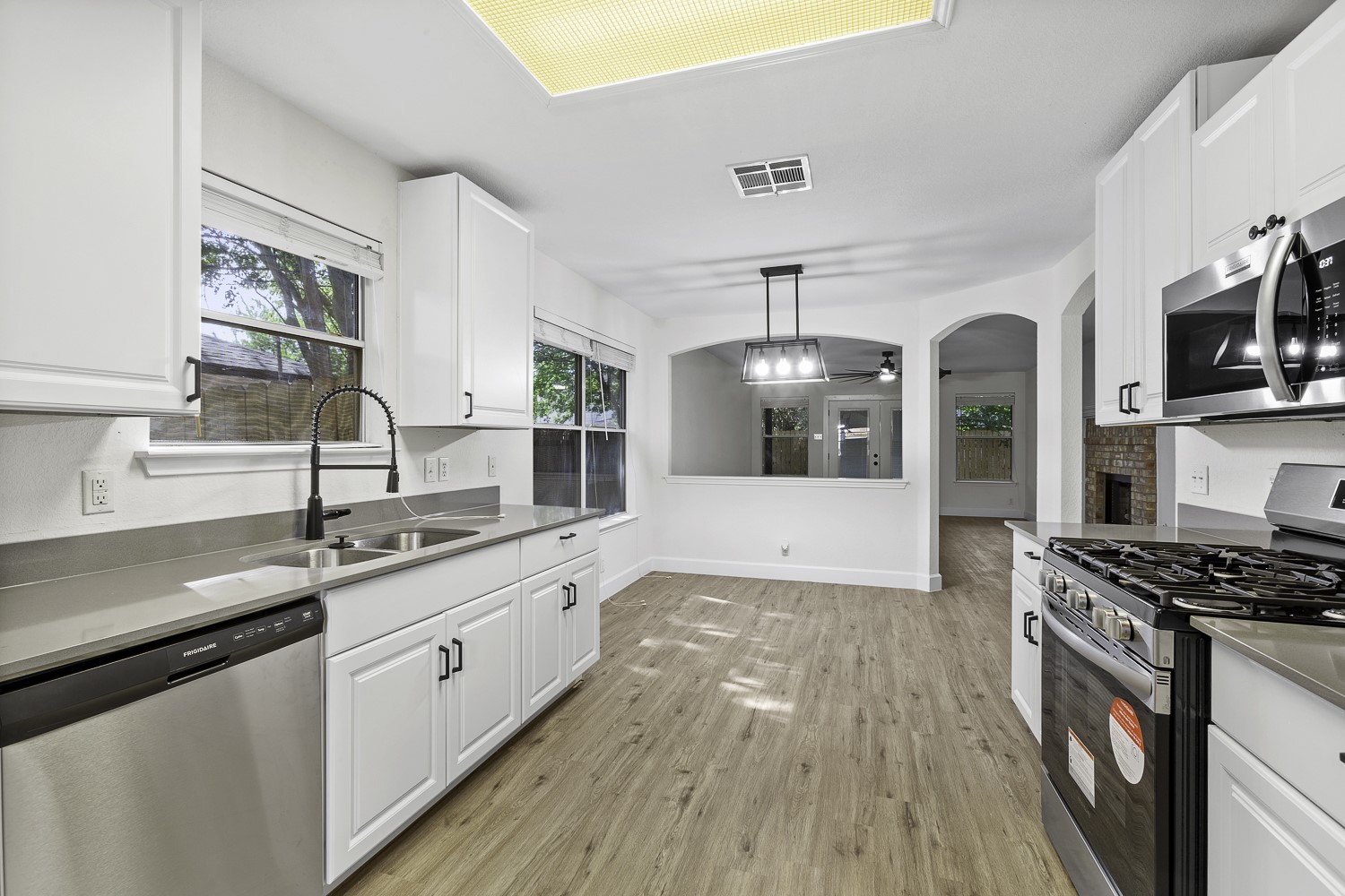 617 Barbara Way Bastrop, TX 78602 - Photo 7 of 39 Kitchen featuring stainless steel appliances, hanging light fixtures, white cabinetry, and light wood-style flooring