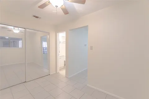 an empty room with fan and entrance