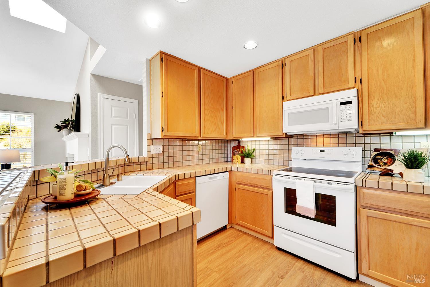 511 Timbercove Street, Unit 8 Vallejo, CA 94591 - Photo 18 of 34 a kitchen with stainless steel appliances kitchen island granite countertop a stove and white cabinets