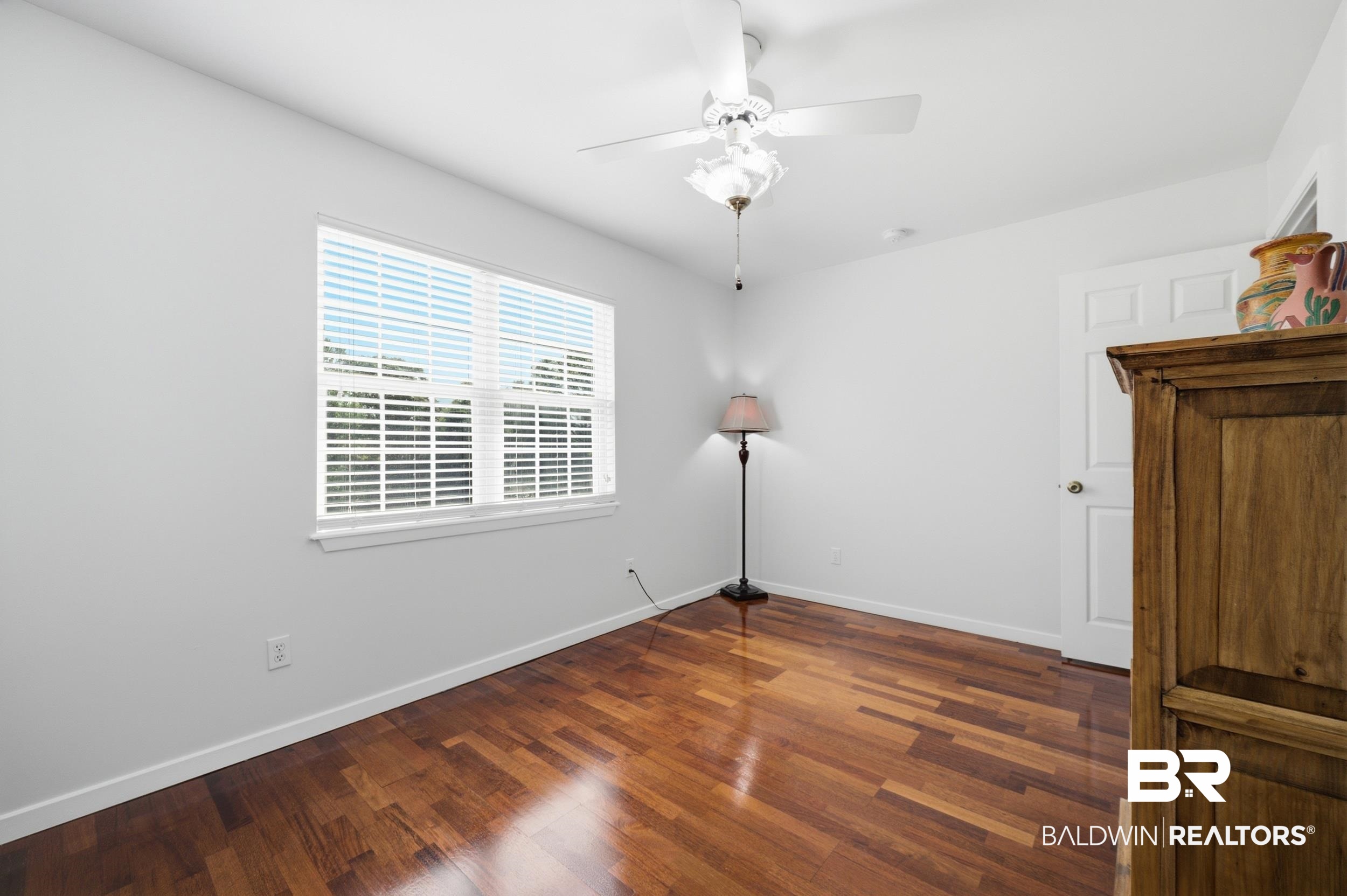 15855 Calvin Richerson Road Bay Minette, AL 36507 - Photo 50 of 83 Light-filled room featuring wood-finish flooring, a white ceiling fan with integrated lighting, a multi-paned window with blinds, and crisp white baseboards
