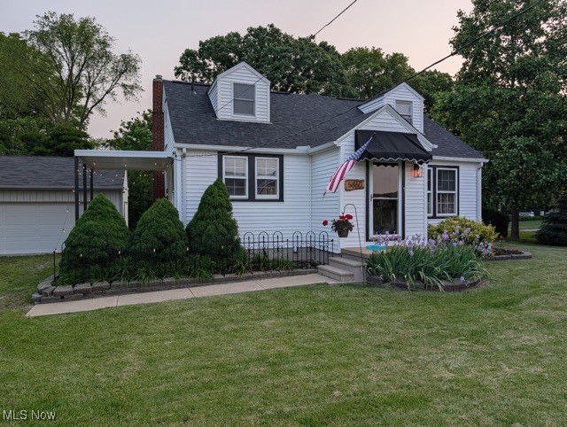 5860 Haber Road Vermilion, OH 44089 - Photo 1 of 31 Cape cod home featuring a chimney, a front yard, roof with shingles, and a garage