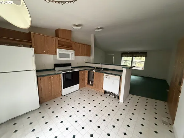 a kitchen with granite countertop a refrigerator and a sink
