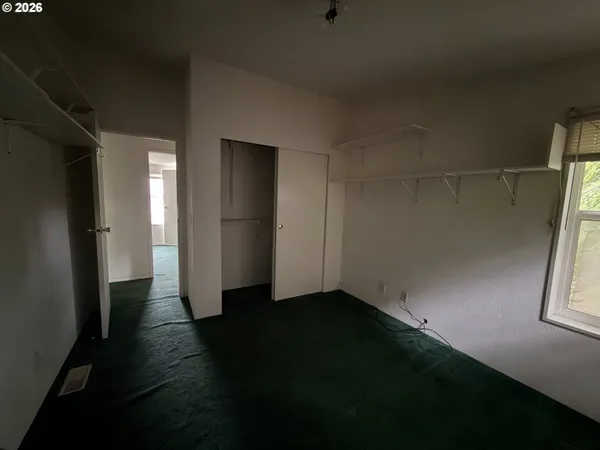 a view of hallway with window and wooden floor