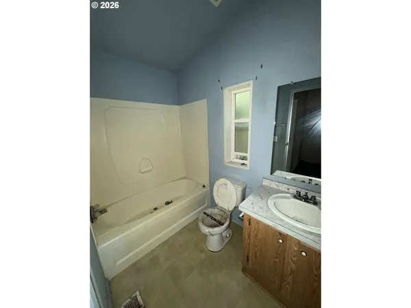 a bathroom with a granite countertop sink a toilet and shower
