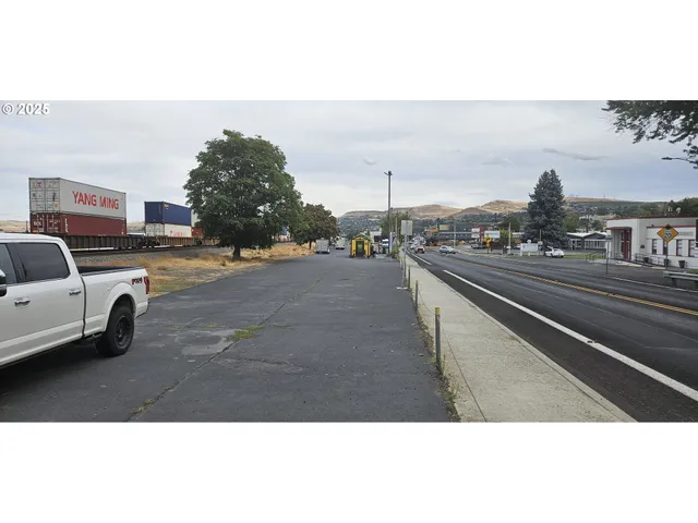 a view of a city street with a car parked on the road
